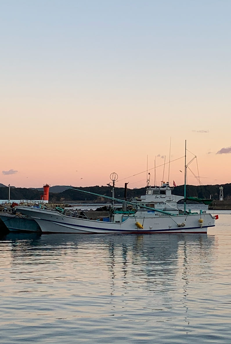 朝日と海と船の写真